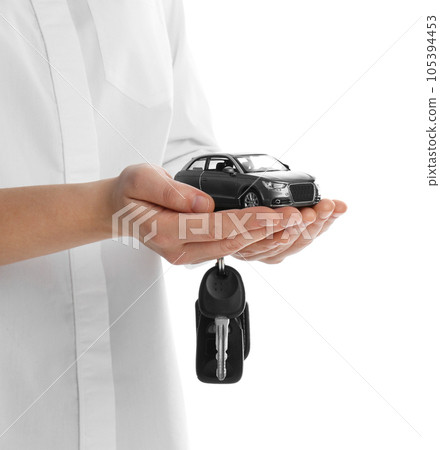 Woman holding key and miniature automobile model on white background, closeup. Car buying 105394453