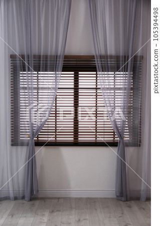Window with beautiful curtains and blinds in empty room Window with beautiful curtains and blinds in empty room 105394498