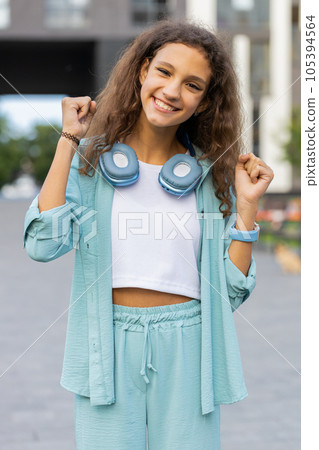 Preteen girl shouting, celebrating success winning goal achievement good victory news in city street 105394564