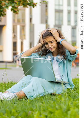 Preteen girl use laptop surprised by bad news fortune loss, fail, lottery results in urban city park Preteen girl use laptop surprised by bad news fortune loss, fail, lottery results in urban city park 105394591
