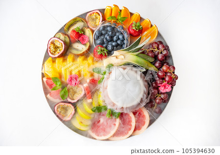 Raw fruits berries assortment platter on the plate, on the white table Raw fruits berries assortment platter on the plate, on the white table 105394630