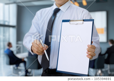 The businessman shows a document for signing . The businessman shows a document for signing . 105394691