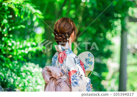 Back view of a woman wearing a yukata with a fan Back view of a woman wearing a yukata with a fan 105394817