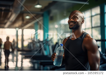 African American man in the gym with a bottle of water in his hands. 105395172