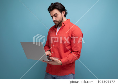 handsome caucasian brunette young businessman holding a laptop in his hands 105395372