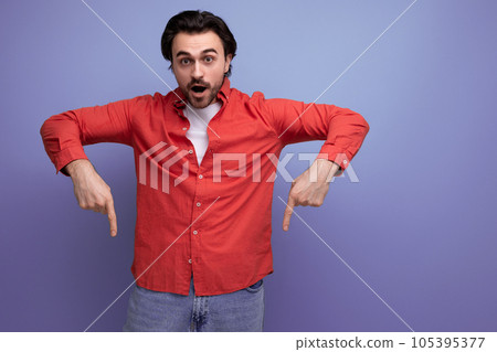 a handsome young brunette man in a red shirt tells interesting news 105395377
