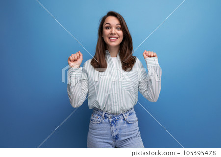 positive pretty young brunet female adult in striped shirt and jeans isolated on plain background positive pretty young brunet female adult in striped shirt and jeans isolated on plain background 105395478