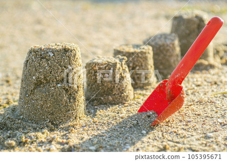 Sand molds and a red baby spatula on the beach. Sand molds and a red baby spatula on the beach. 105395671