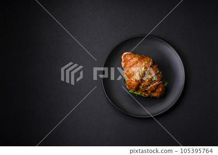 Delicious crispy croissant with salmon, lettuce, cheese and tomatoes 105395764