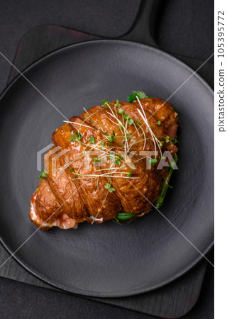 Delicious crispy croissant with salmon, lettuce, cheese and tomatoes 105395772