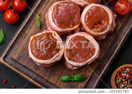 Delicious raw fresh pork or chicken meat rolls wrapped in bacon Delicious raw fresh pork or chicken meat rolls wrapped in bacon 105395793