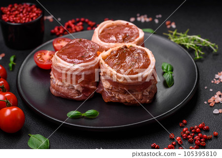 Delicious raw fresh pork or chicken meat rolls wrapped in bacon Delicious raw fresh pork or chicken meat rolls wrapped in bacon 105395810
