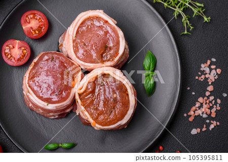 Delicious raw fresh pork or chicken meat rolls wrapped in bacon Delicious raw fresh pork or chicken meat rolls wrapped in bacon 105395811