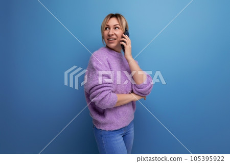 smiling pleasant blond young woman chatting on the phone on a bright colorful background 105395922