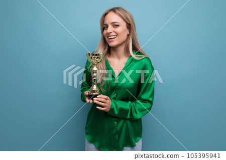 cute girl with championship cup on blue bright background with empty space cute girl with championship cup on blue bright background with empty space 105395941