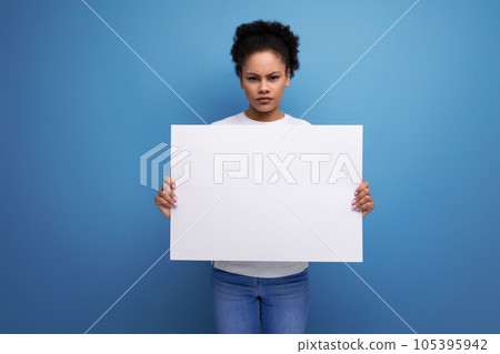 young brunette woman with afro hair in a white tank top holding a white board sheet with space for young brunette woman with afro hair in a white tank top holding a white board sheet with space for 105395942