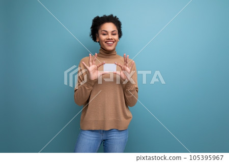 isolated background, cute young brunette hispanic woman with ponytail hairstyle holding credit card 105395967