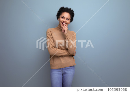 young pretty latin woman with curly hair smiles with a wide smile on the background with copy space 105395968