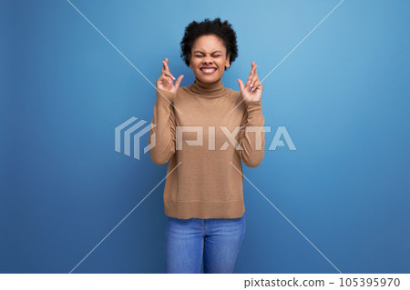positive young bright latino woman with afro hair gathered in a ponytail against the background with positive young bright latino woman with afro hair gathered in a ponytail against the background with 105395970