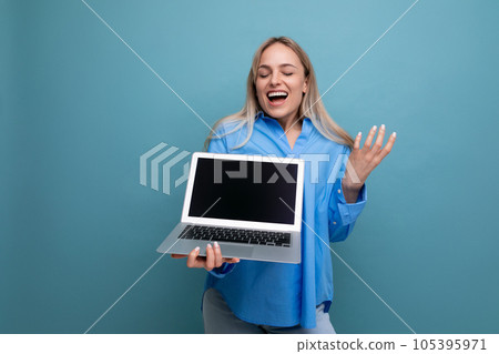 happy lucky blonde girl rejoices with a laptop in her hands with an empty space for a web page on a happy lucky blonde girl rejoices with a laptop in her hands with an empty space for a web page on a 105395971