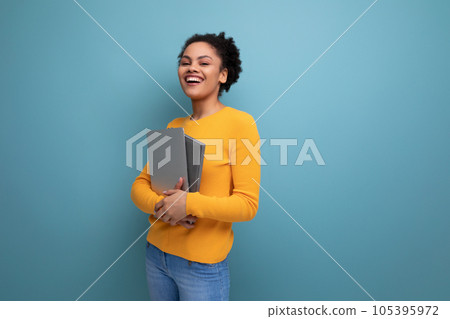 successful young 25 year old hispanic lady student with afro tail holding a laptop in her hands successful young 25 year old hispanic lady student with afro tail holding a laptop in her hands 105395972