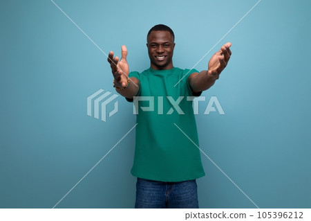 young positive friendly african guy with a short haircut dressed in a basic t-shirt against the 105396212
