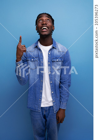 close-up portrait of a handsome young stylish american guy with curls in denim clothes close-up portrait of a handsome young stylish american guy with curls in denim clothes 105396273