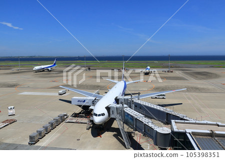 Passenger plane preparing for departure Loading cargo, connecting boarding bridge Passenger plane preparing for departure Loading cargo, connecting boarding bridge 105398351