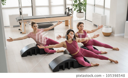 Balanced Body Pilates Arc. Three asian women exercising on pilates arc. Balanced Body Pilates Arc. Three asian women exercising on pilates arc. 105398548