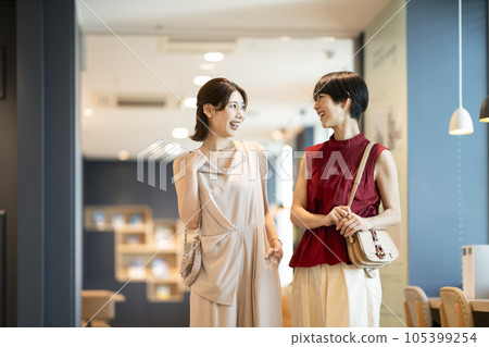 Two Arasa women walking while talking with a smile Two Arasa women walking while talking with a smile 105399254