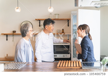 一位女商人（冰箱）在家電零售店、住宅展廳、樣板間、電器店向一對老年夫婦解釋 105400759
