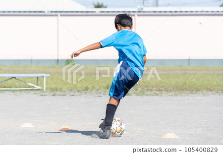 Elementary school boy practicing soccer 105400829