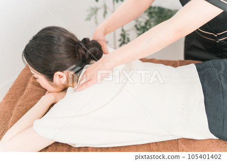 一名女按摩師、治療師、脊椎按摩師和物理治療師在美容沙龍/推拿診所按摩她的肩膀 一名女按摩師、治療師、脊椎按摩師和物理治療師在美容沙龍/推拿診所按摩她的肩膀 105401402