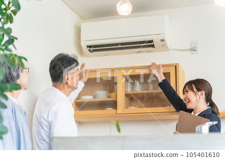 女商人在房屋展廳、樣板間、房屋製造商（空調、空調）向一對老年夫婦解釋 105401610