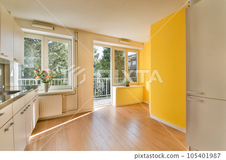 a kitchen with yellow walls and wood flooring in the middle of the room, there is an open door that leads to a a kitchen with yellow walls and wood flooring in the middle of the room, there is an open door that leads to a 105401987