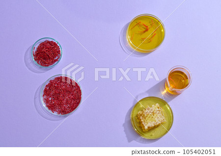 Minimal style, advertising photo for product extracted from saffron and honey on purple background. Saffron soaked in honey helps to improve the immune system and increase resistance 105402051