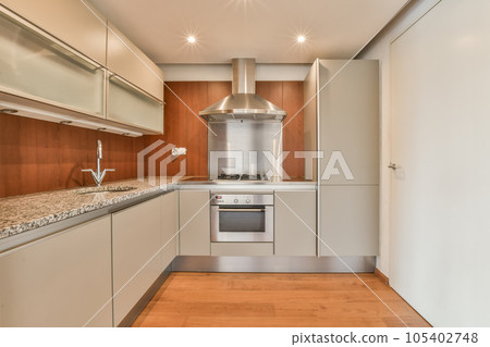a modern kitchen with wood flooring and stainless steel appliances in the cabinetd area is very clean, but it's not 105402748