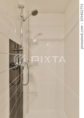 a bathroom with white tiles and black shower headphones on the wall above it is an image of a walk - in shower 105402753