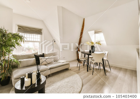a living room with white walls and wood flooring in the center of the room there is a couch, coffee table, chair a living room with white walls and wood flooring in the center of the room there is a couch, coffee table, chair 105403400