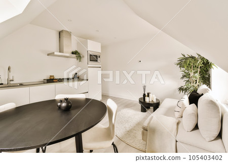 a living room with white couches and a black table in the center of the room is an open kitchen a living room with white couches and a black table in the center of the room is an open kitchen 105403402