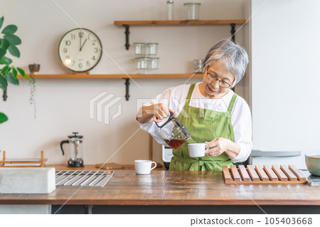Asian elderly woman brewing coffee in the kitchen of the house/cafe Asian elderly woman brewing coffee in the kitchen of the house/cafe 105403668