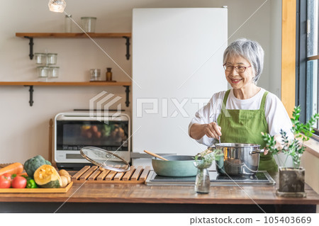 Asian senior / elderly woman cooking in the kitchen at home (smile) 105403669