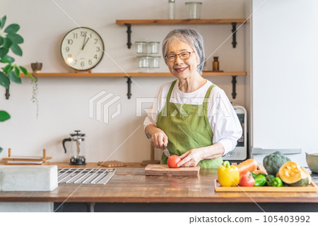 Asian elderly woman cooking food in home kitchen Asian elderly woman cooking food in home kitchen 105403992