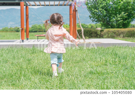 Back view of a child playing and running in the park 105405080