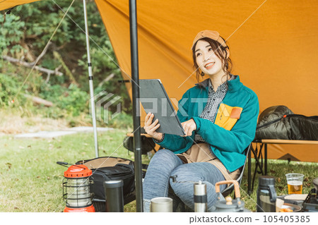 A young female camper camping solo at a campsite (reading/reading a book) A young female camper camping solo at a campsite (reading/reading a book) 105405385