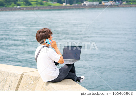 A man working as a tour planner looking at the sea A man working as a tour planner looking at the sea 105405908