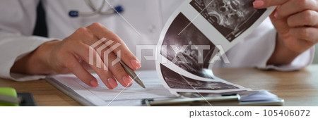 Close up of female doctor checking medical results at workplace in clinic. Close up of female doctor checking medical results at workplace in clinic. 105406072