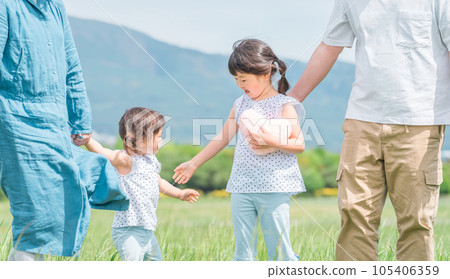 Sister children walking hand in hand with their parents 105406359