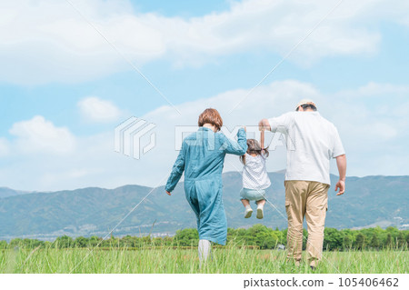 Family, parent and child, back view of family walking while holding hands and jumping in the park (children, parents, travel) 105406462