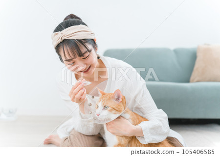 Owner's woman trying to put eye drops on a cat (medication / illness) 105406585